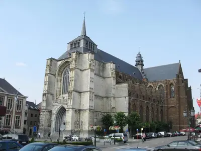 a large cathedral with cars parked in front of it at Oranje City Hotel in Diest