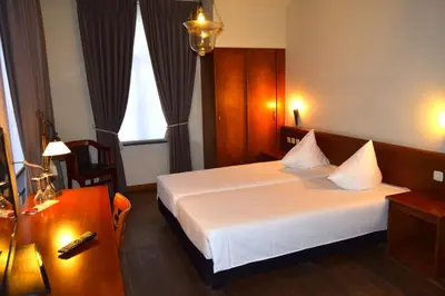 a hotel room with a bed and a desk at Oranje City Hotel in Diest