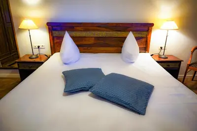 a white bed with two pillows on top of it at Oranje City Hotel in Diest
