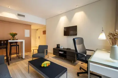 a living room with a table and chairs and a desk at B-aparthotel Grand Place in Brussels