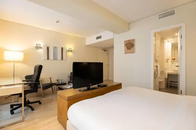 a hotel room with a bed and a desk and a television at B-aparthotel Grand Place in Brussels