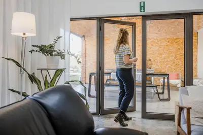 a woman standing in a living room looking out the door at Viktoria Guesthouse in Westerlo