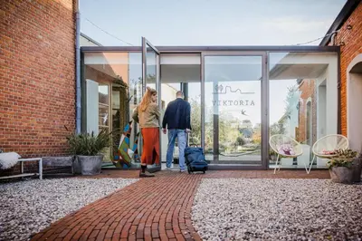 a man and a woman standing outside of a store window at Viktoria Guesthouse in Westerlo