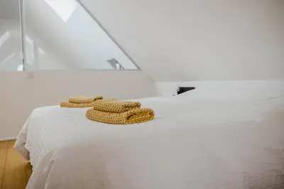 two towels on top of a white bed at Viktoria Guesthouse in Westerlo