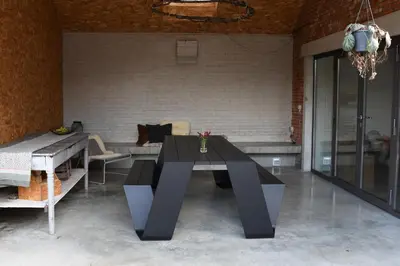 a dining room with a black table and chairs at Viktoria Guesthouse in Westerlo