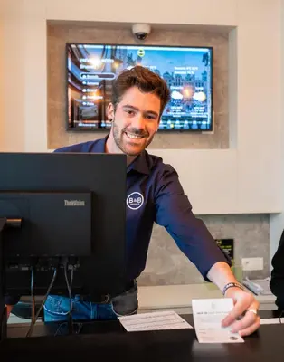 a man sitting at a desk in front of a computer at B&B HOTEL Brussels Centre Gare du Midi in Brussels