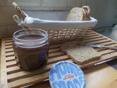 a table with a jar of peanut butter and a basket of bread at B&B Chambre Chocolat in Brussels
