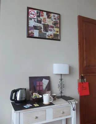 a table with a lamp and a picture on the wall at B&B Chambre Chocolat in Brussels