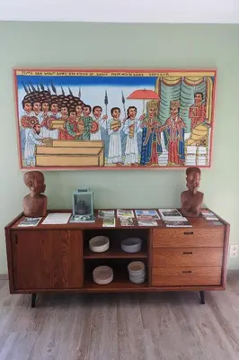 a wooden table with a painting on the wall at t Sutterhuisje, zalig slapen aan het Donkmeer in Donk