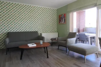 a living room with a couch and chairs and a table at t Sutterhuisje, zalig slapen aan het Donkmeer in Donk