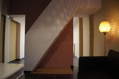 a living room with a couch and a staircase at All Inn Holiday Home in Ghent