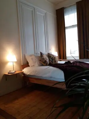 a bedroom with a bed with two pillows and a window at Quiet apartment in Antwerp near parc - B&B InterMezzo - business & leisure in Antwerp