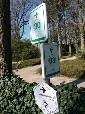 two signs on a pole in a park at Quiet apartment in Antwerp near parc - B&B InterMezzo - business & leisure in Antwerp