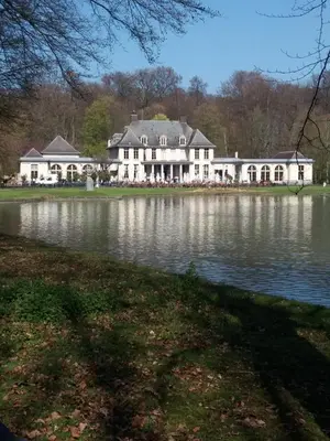 a large white house in front of a lake at Quiet apartment in Antwerp near parc - B&B InterMezzo - business & leisure in Antwerp
