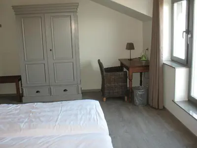 a bedroom with a bed and a desk and a chair at B&B La Vie En Roses in Moorsel
