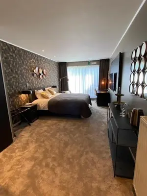 a large bedroom with a bed and a window at Hotel Thermen Mineraal in Rijmenam