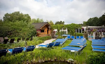 a group of chairs and lounge chairs in a yard at Hotel Thermen Mineraal in Rijmenam