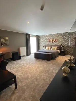 a large bedroom with a bed and a couch at Hotel Thermen Mineraal in Rijmenam