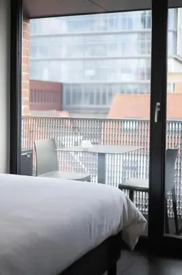 a bedroom with a bed and a view of a balcony at Designflats Gent in Ghent