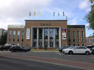 a large building with cars parked in a parking lot at Designflats Gent in Ghent