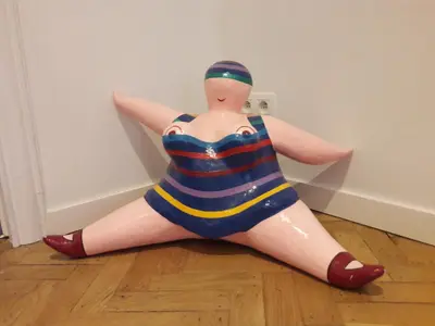 a plastic doll in a swimsuit sitting on the floor at Un grand jardin en ville. Chez Guy in Brussels