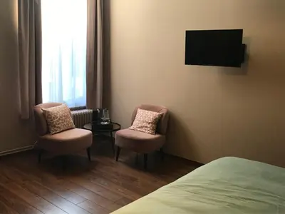 a hotel room with two chairs and a tv at B&B Inn Between in Ghent