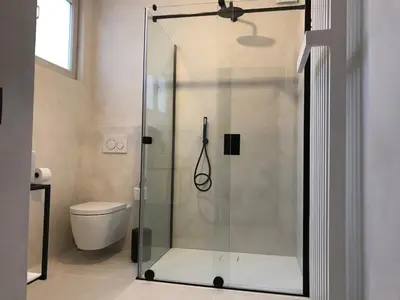 a glass shower in a bathroom with a toilet at B&B Inn Between in Ghent
