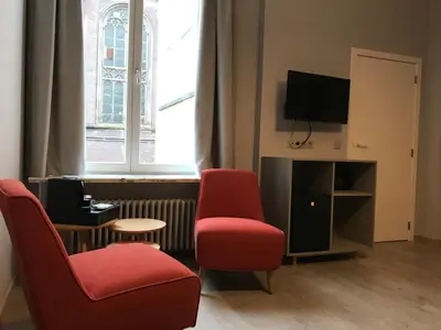 a living room with two chairs and a tv at B&B Inn Between in Ghent