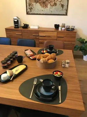 a wooden table with a plate of food on it at B&B Inn Between in Ghent