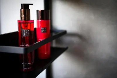 two red bottles sitting on a black shelf at B&B Hof ter Kouter in Dworp