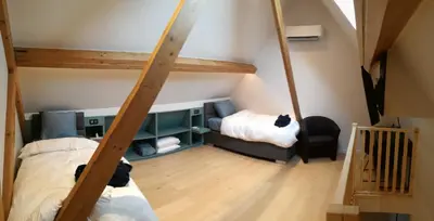 a room with two bunk beds and a staircase at B&B Hof ter Kouter in Dworp