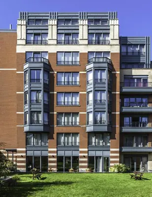 a large brick building with a lawn in front of it at Diamant Suites Brussels EU in Brussels