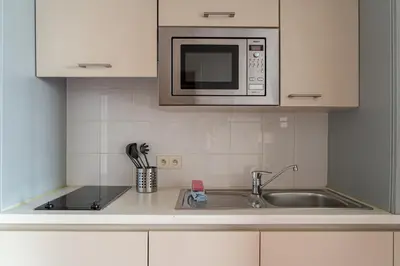 a kitchen with a sink and a microwave at Diamant Suites Brussels EU in Brussels