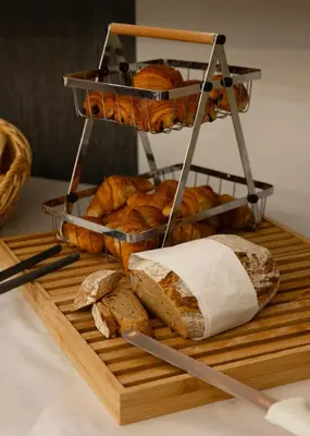 a tray of bread and loaves of bread on a table at Diamant Suites Brussels EU in Brussels