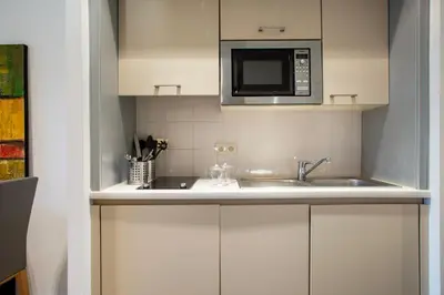 a kitchen with a sink and a microwave at Diamant Suites Brussels EU in Brussels