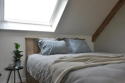 a bedroom with a bed with a large window at Bed en Bezem in Laarne