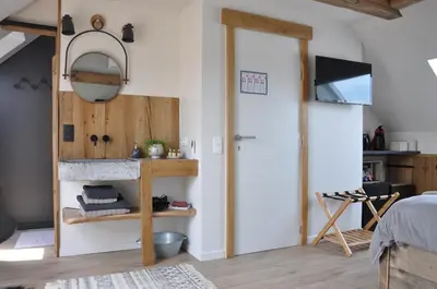a bedroom with a door leading into a room with a fireplace at Bed en Bezem in Laarne