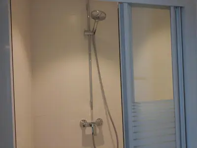 a shower with a shower head in a bathroom at Pluimpapaver Hotel & Glamping in Aarschot