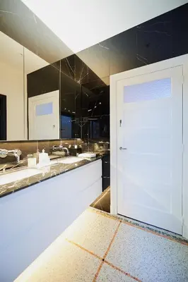 a bathroom with two sinks and a large white door at B&B Suites 124 in Brussels
