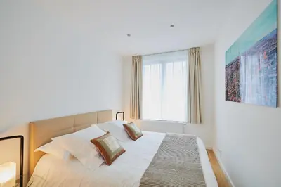 a bedroom with a bed with pillows and a window at B&B Suites 124 in Brussels