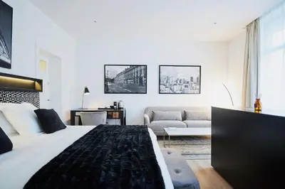 a bedroom with a large bed and a living room at B&B Suites 124 in Brussels