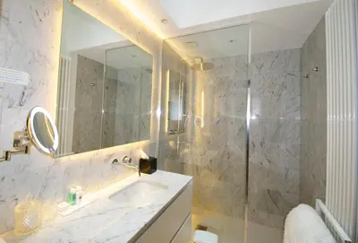 a bathroom with a sink and a shower with a mirror at B&B Suites 124 in Brussels
