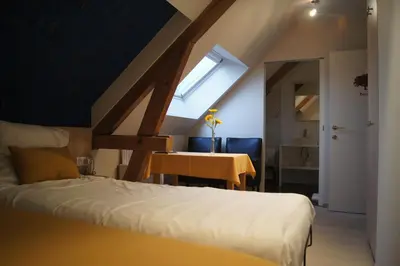 a bedroom with a bed and a table and a window at B&B Het Wouwe in Herentals