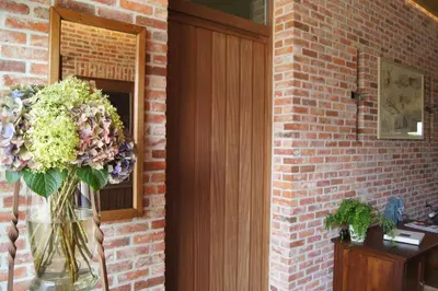a door with a vase of flowers next to a brick wall at B&B Het Wouwe in Herentals