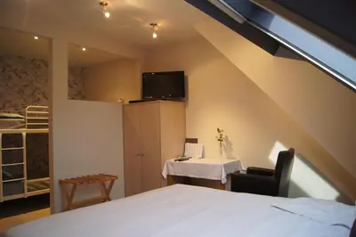 a bedroom with a bed and a table and a tv at B&B Het Wouwe in Herentals
