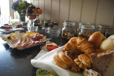 a table with a bunch of bread and pastries on it at B&B Het Wouwe in Herentals