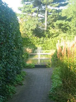 a garden with a fountain in the middle of a path at B & B DE SERAFIJN in Lochristi