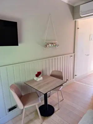 a dining room with a wooden table and two chairs at B & B DE SERAFIJN in Lochristi