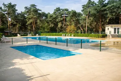 a swimming pool with a fence around it at Safaritent at Camping GT Keiheuvel in Balen