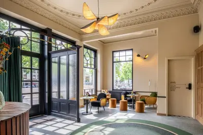 a lobby with tables and chairs and large windows at Made in Catherine in Brussels